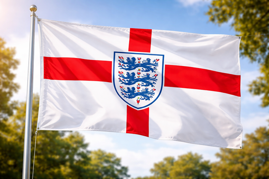 Flag with a red cross and blue emblem on a white background, waving in the wind with trees and blue sky in the background.