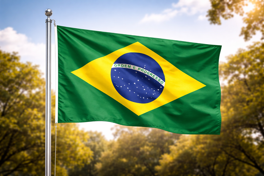 Brazilian flag waving in the wind with trees and blue sky in the background